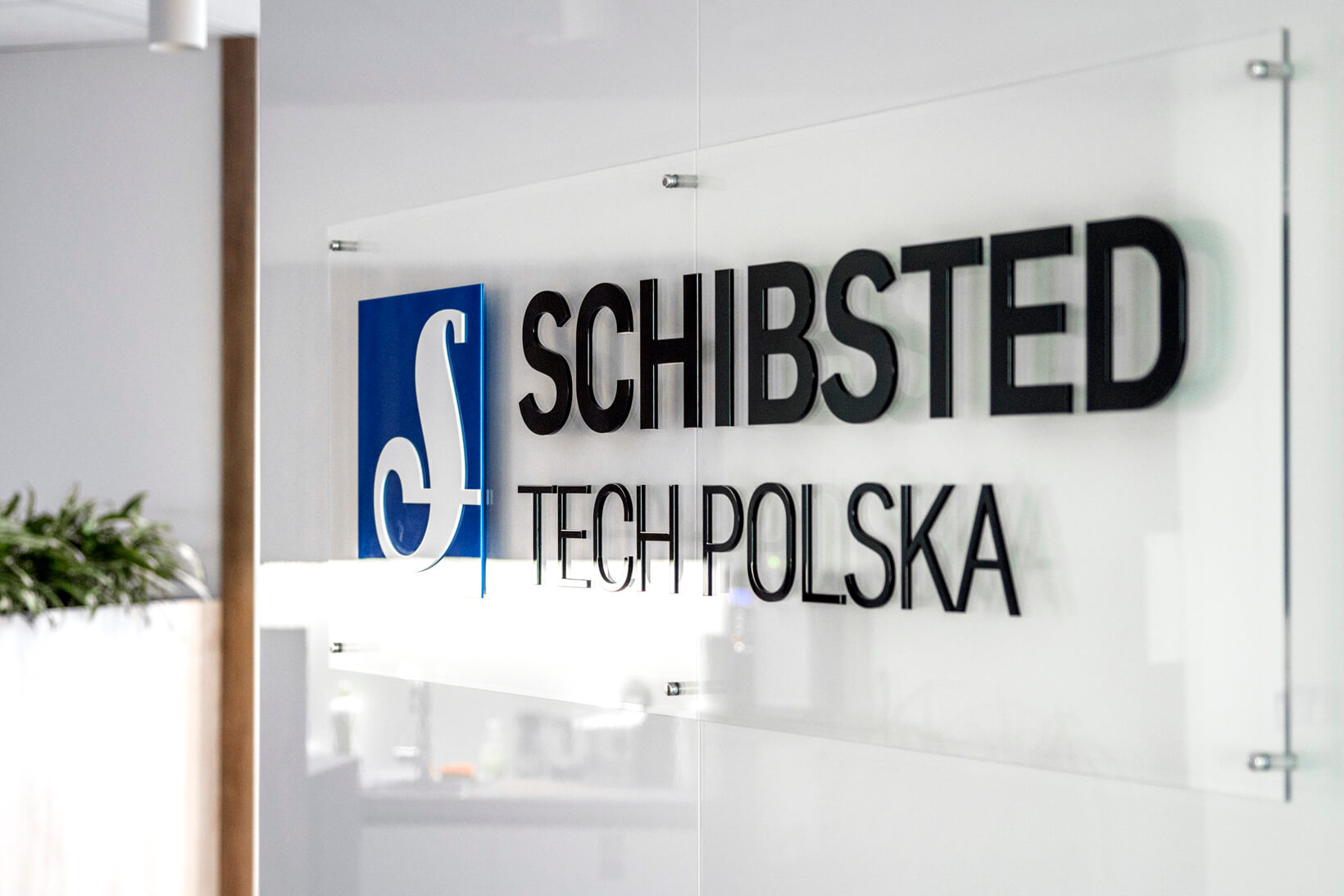 Schibsted Tech Polska - 3D-logo en ruimtelijke letters op plexiglazen voet op afstanden in ontvangstruimte